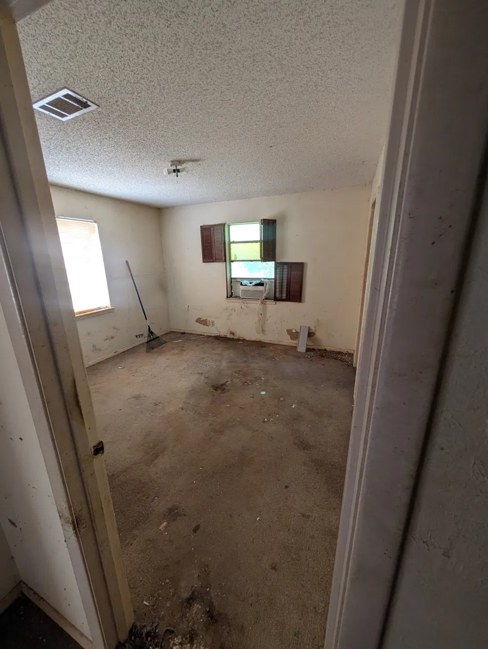 Empty bedroom in distressed DFW rental property before full renovation