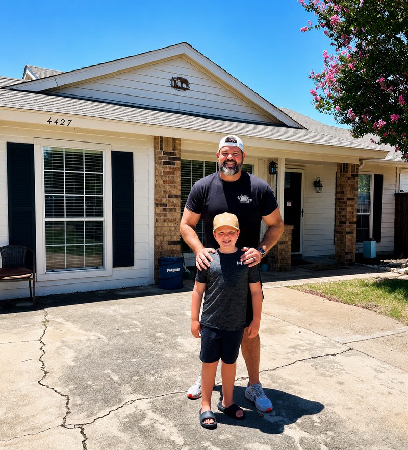 Nick Good standing outside a home with family